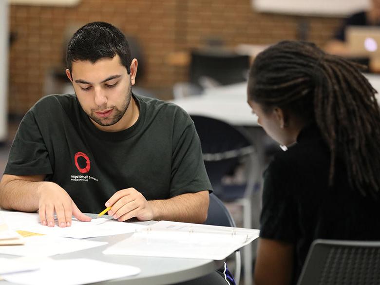 Male tutor teaching female student